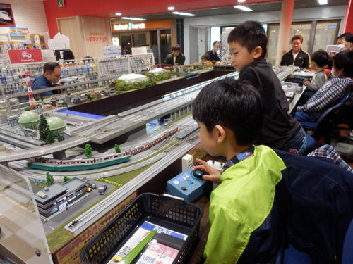 地下街アゼリアの｢高感度な大人向け｣というコンセプトに合わせて､鉄道模型の人形と生活用品を組み合わせたお洒落な展示を実施