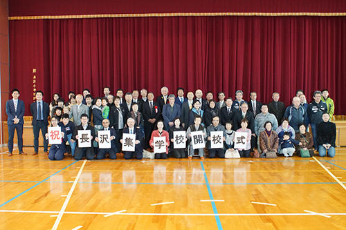 長沢集学校のオープンを体育館で祝う人々