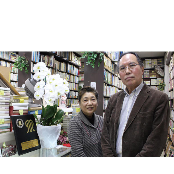 西田書店代表取締役の佐藤健二さん（右）と妻の佐藤純子さん。左にあるのが表彰の盾